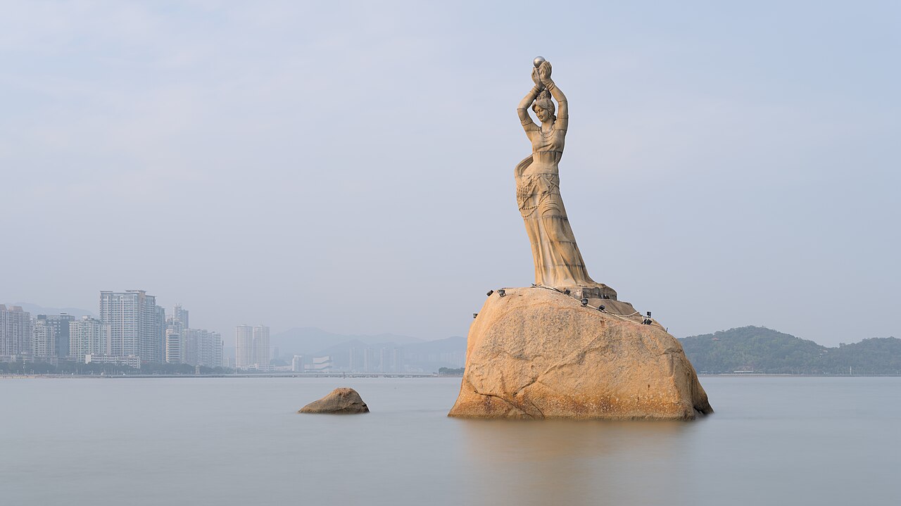 珠海漁女雕像矗立於香爐灣,遠處可見城市海岸